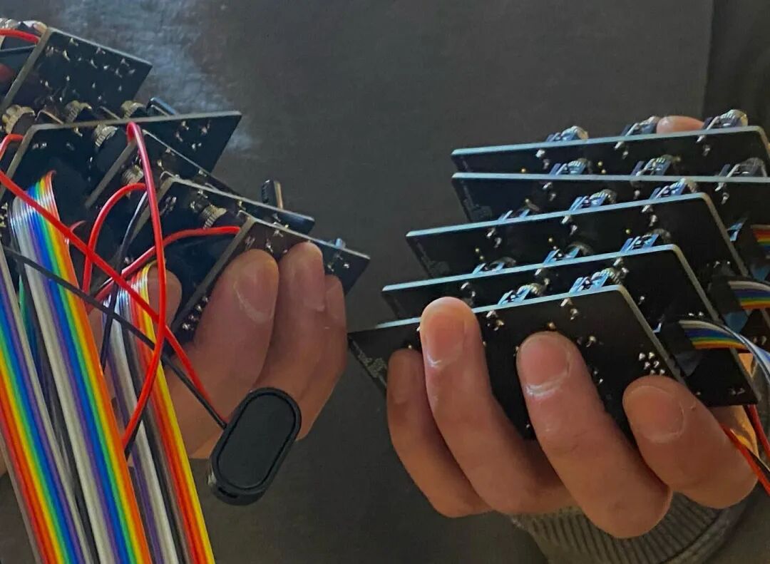 two handfuls of assembled module boards with ribbon and power cables