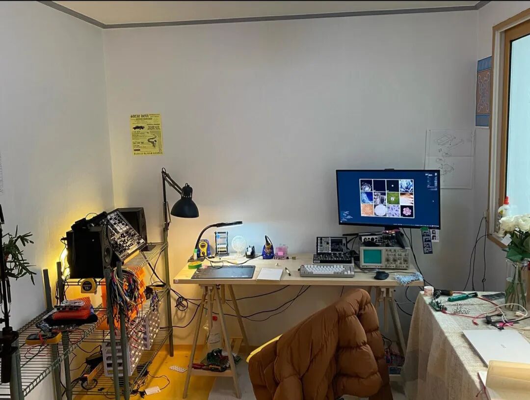 the workbench: modular rack, soldering station, oscilloscope, and monitor